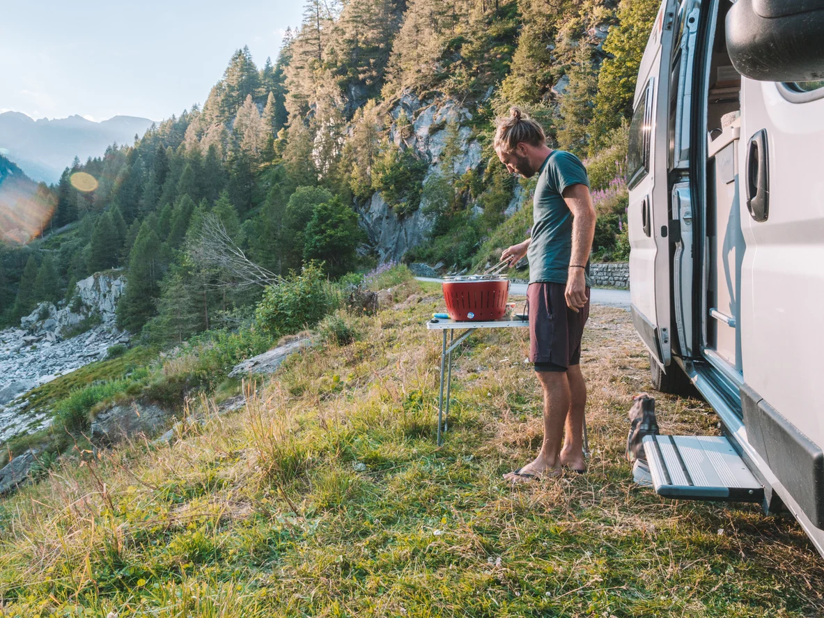 a man cooking food in a camper van