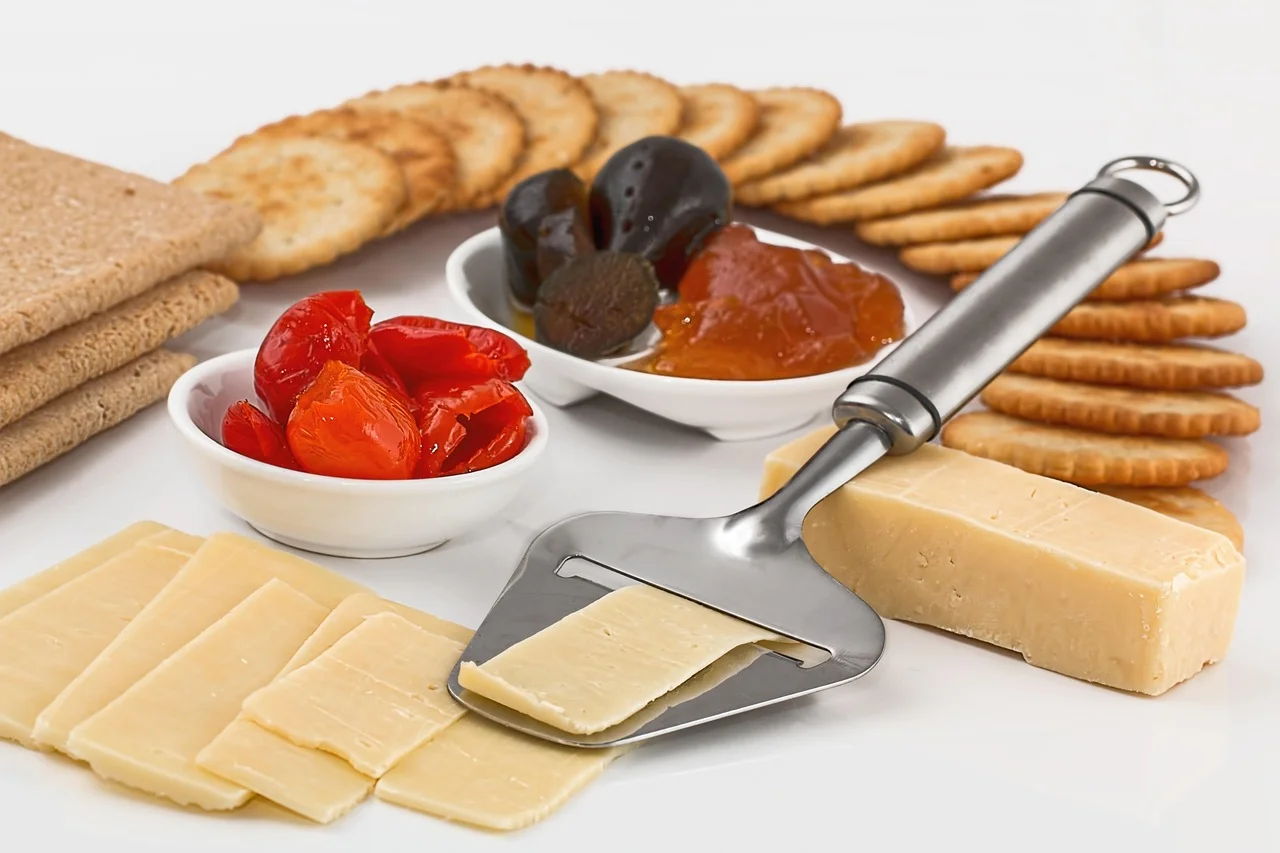 Urval av ostar, kex och handbakat bröd på rustikt bord